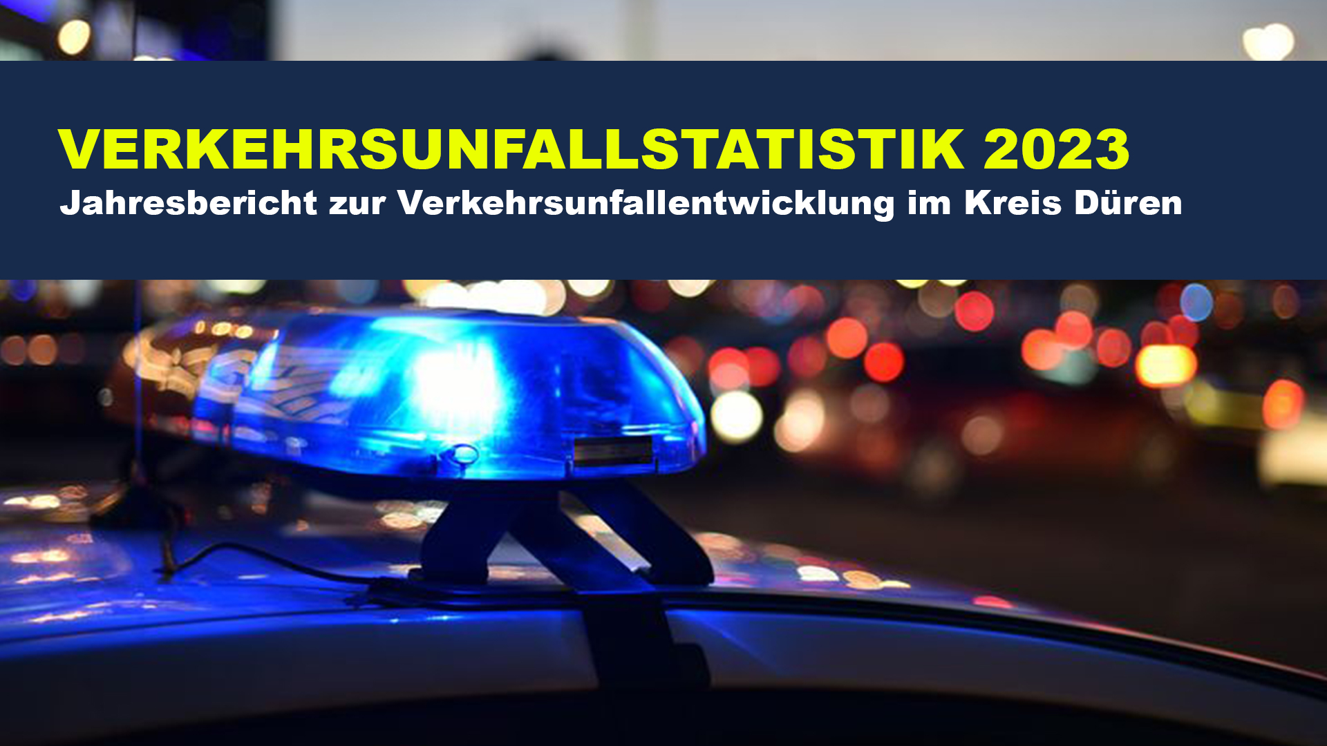 Text: Verkehrsunfallstatistik 2023 Jahresbericht zur Verkehrsunfallentwicklung im Kreis Düren. Im Hintergrund in Blaulicht auf Auto bei Dunkelheit draußen