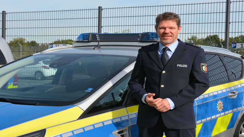 PD Georg Lehnen vor einem Streifenwagen