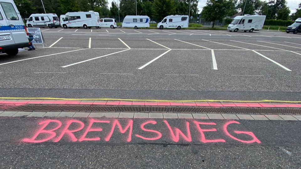 Auf den Asphalt auf einem Parkplatz wurden mit roter und gelber Farbe zwei lange Streifen gemalt. Sie stehen für die Länge des Reaktions- und den Bremsweges bei einer Geschwindigkeit von 50 km/h.